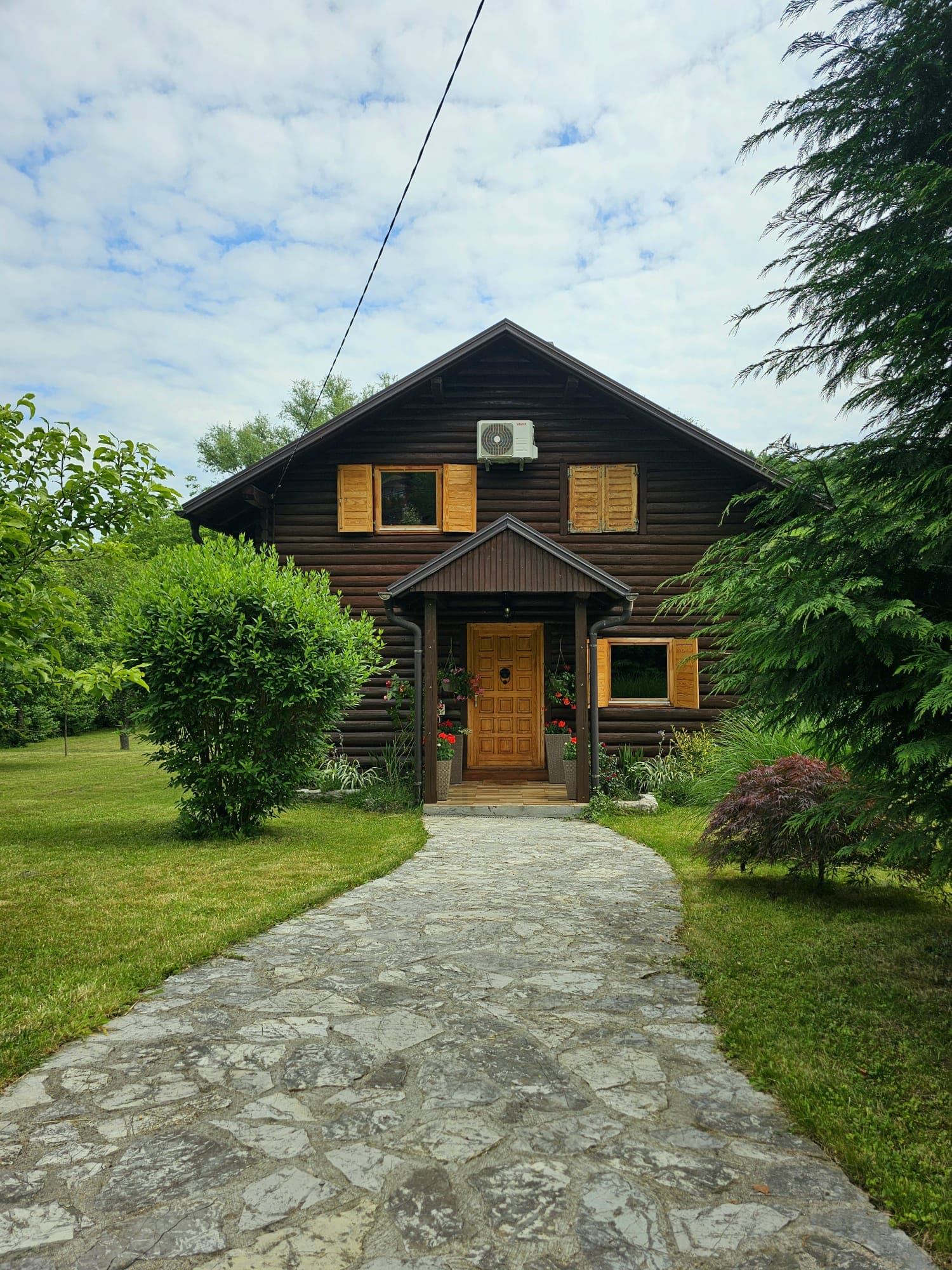 Wooden holiday home surrounded by a green garden and trees